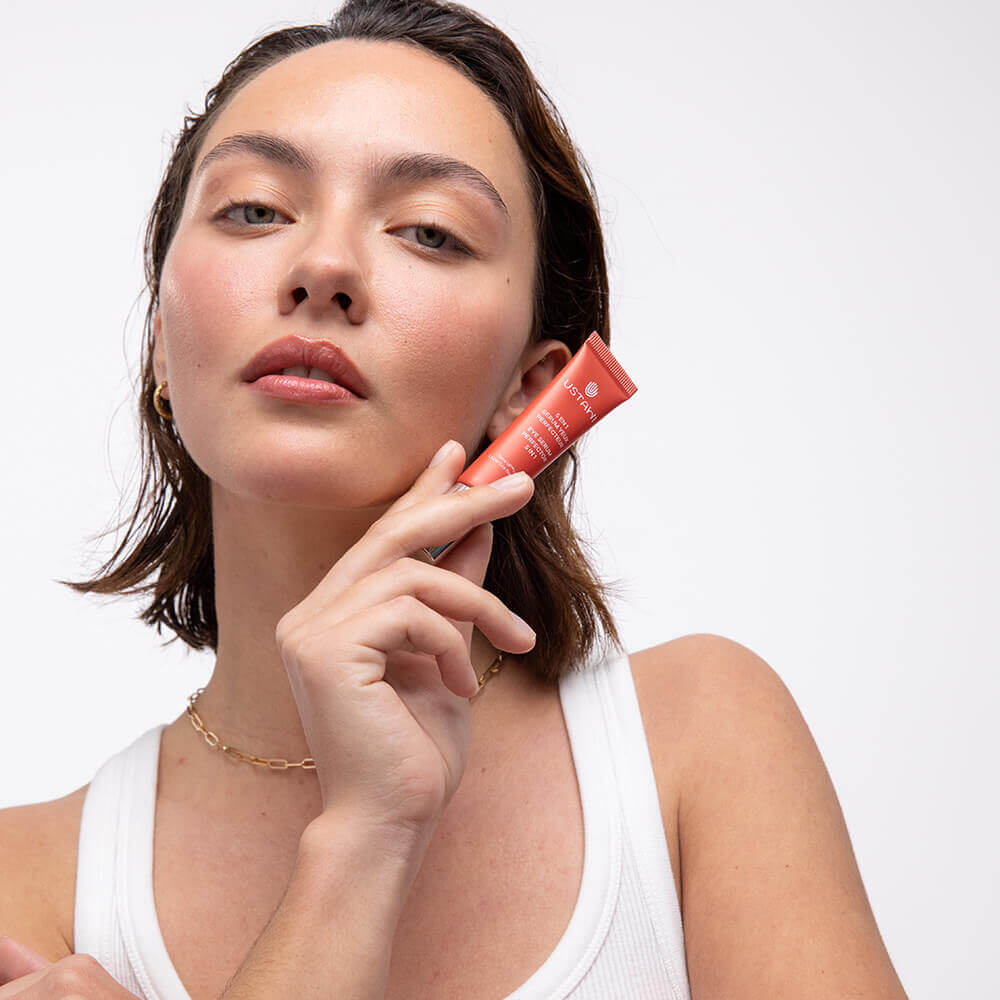 Woman showcasing the USTAWI 5-in-1 Eye Serum Perfector made with natural ingredients